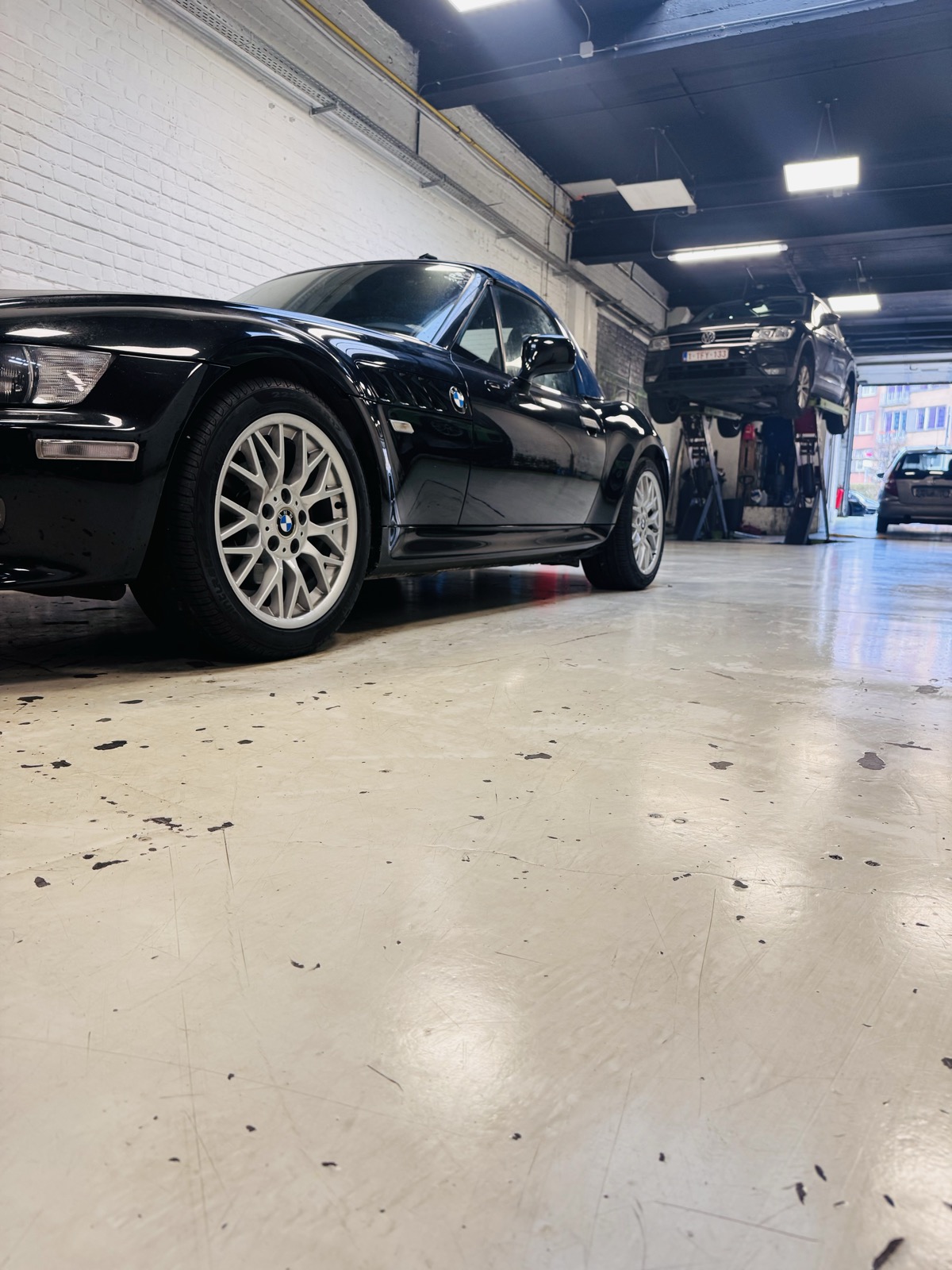 Mécanicien SD Motors qui explique une réparation à un client dans l'atelier à Evere